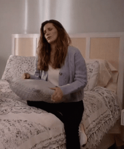 Woman Sitting On Bed With Pillow GIF