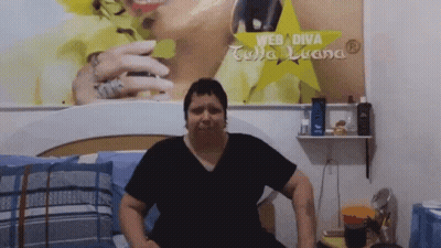 Woman Sitting On Bed With Web Diva Sign GIF