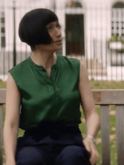 Woman Sitting On Bench Green Top Blue Pants GIF