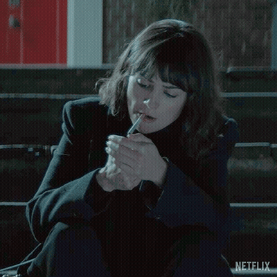Woman Sitting On Bench Lighting Cigarette GIF