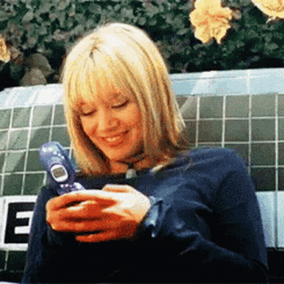 Woman Sitting On Bench Using Cell Phone GIF