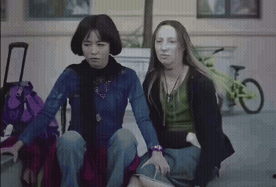 Woman Sitting On Bench With Purple Suitcase GIF