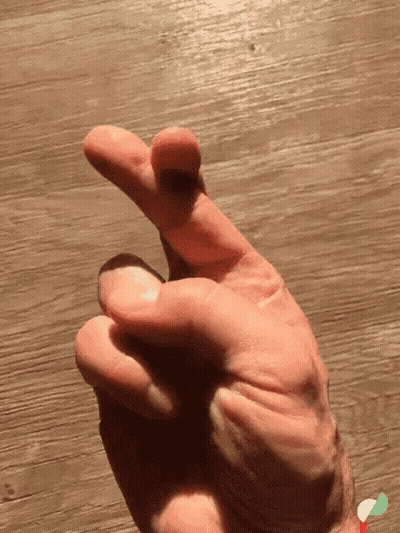 Woman Sitting On Couch Fingers Crossed GIF