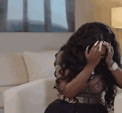 Woman Sitting On Couch Hands On Face GIF
