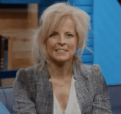 Woman Sitting On Couch In Blazer And White Shirt GIF