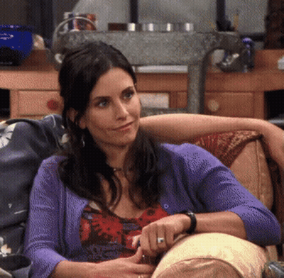 Woman Sitting On Couch In Purple Cardigan GIF