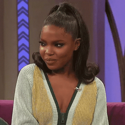Woman Sitting On Couch In Zippered Sweater GIF