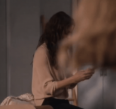 Woman Sitting On Couch Looking At Phone GIF