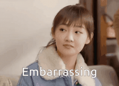 Woman Sitting On Couch Making Embarrassed Face GIF