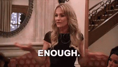 Woman Sitting On Couch Saying Enough With Arms Outstretched GIF