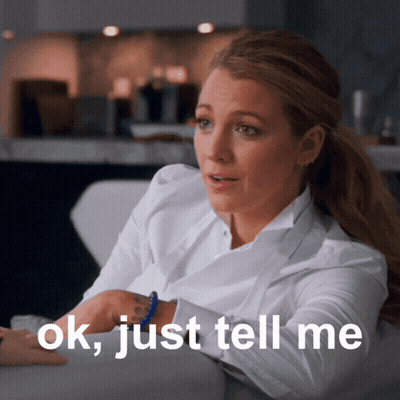 Woman Sitting On Couch Saying Ok Just Tell Me GIF
