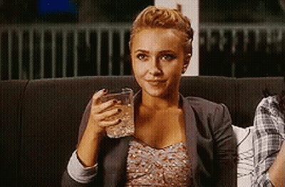 Woman Sitting On Couch Smiling Holding Glass Of Water GIF