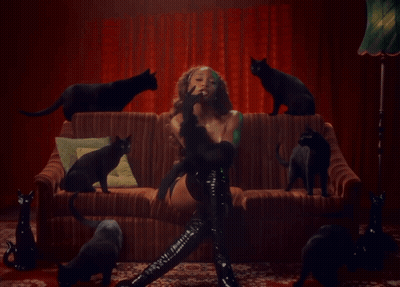Woman Sitting On Couch With Black Cats GIF