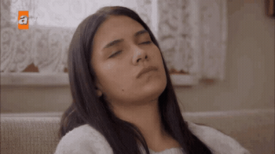 Woman Sitting On Couch With Eyes Closed GIF