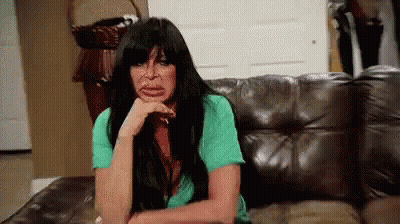 Woman Sitting On Couch With Hand On Chin GIF