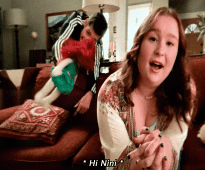 Woman Sitting On Couch With Man Behind Her Says Hi Nini GIF