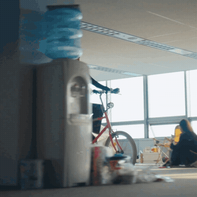 Woman Sitting On Floor By Bicycle And Water Cooler GIF