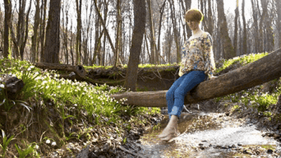 Woman Sitting On Log In Stream GIF