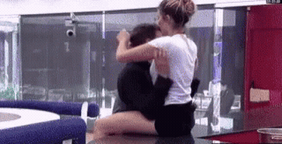 Woman Sitting On Man's Lap On Counter GIF