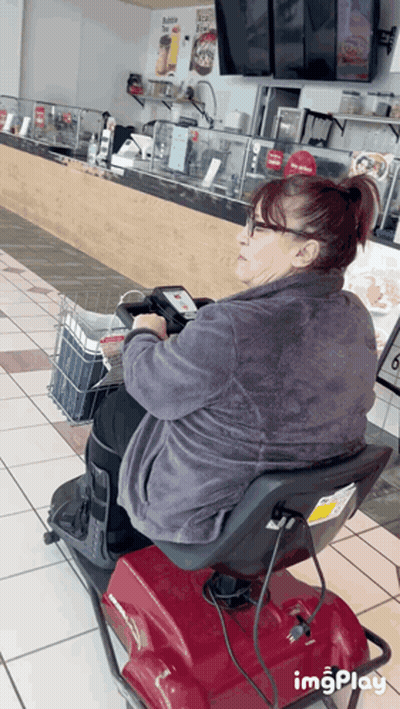 Woman Sitting On Mobility Scooter In Restaurant GIF