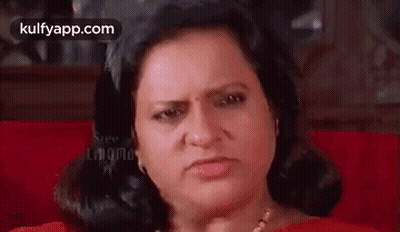 Woman Sitting on Red Couch Making Angry Face