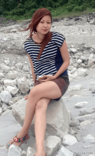 Woman Sitting On Rock With Muglife Watermark GIF