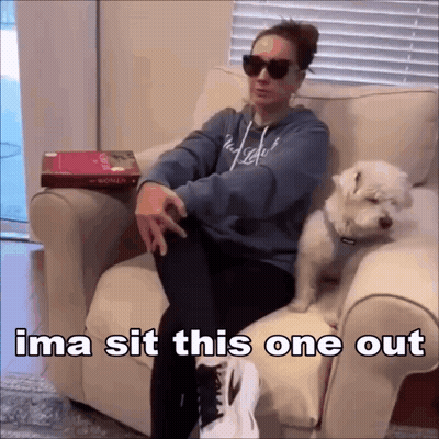 Woman Sitting With Dog On Lap And Book On Table GIF