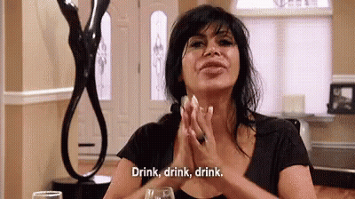 Woman Sitting With Wine Saying Drink Drink Drink GIF