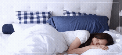 Woman Sleeping On Bed With Blue And White Pillows GIF
