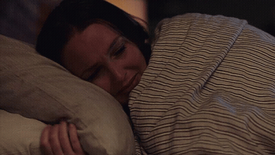 Woman Sleeping Under Striped Blanket GIF