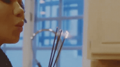Woman Smelling Candle By Window GIF