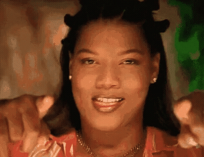 Woman Smiling And Pointing At Camera With Necklace And Earrings GIF