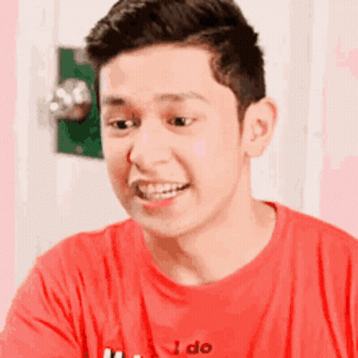 Woman Smiling And Waving On Couch GIF