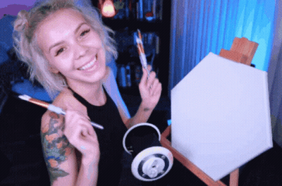 Woman Smiling Holding Brush And Canvas On Easel GIF