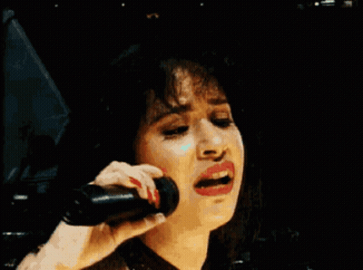 Woman Smiling Holding Microphone To Ear GIF