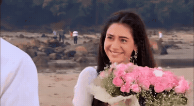 Woman Smiling Holding Pink Roses On Beach GIF