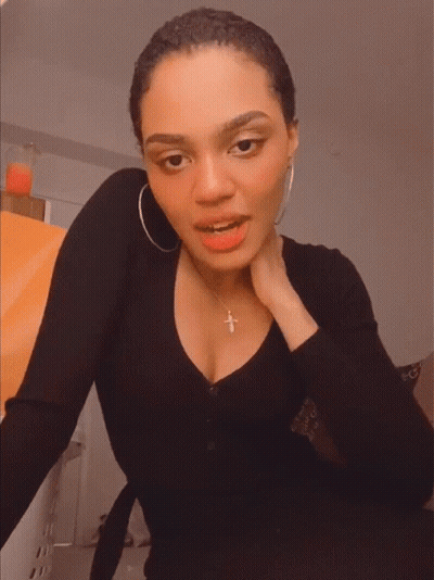 Woman Smiling In Black Shirt With Cross Necklace GIF