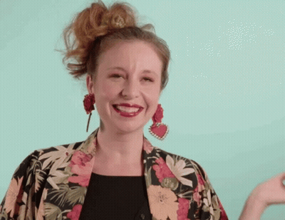 Woman Smiling In Floral Jacket And Earrings GIF