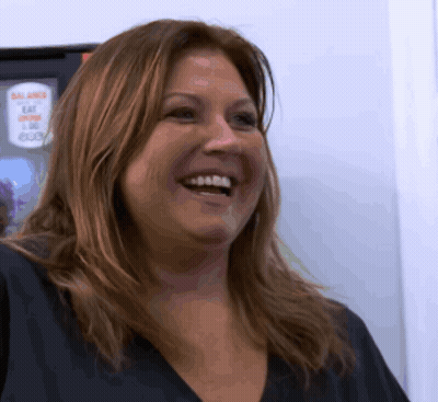 Woman Smiling In Front Of Balance Sign GIF