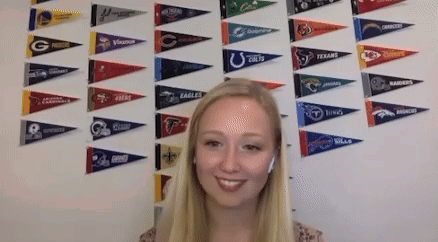 Woman Smiling In Front Of Eagles Pennants GIF