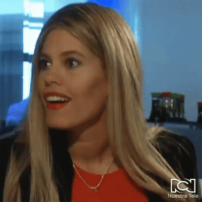 Woman Smiling In Front Of Nuestra Tele Sign GIF