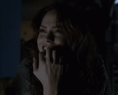 Woman Smiling In The Dark With Hand On Face GIF