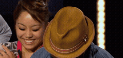 Woman Smiling Next To Man With Hat GIF
