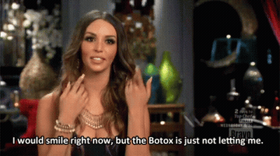 Woman Smiling Talking About Botox On Red Couch GIF