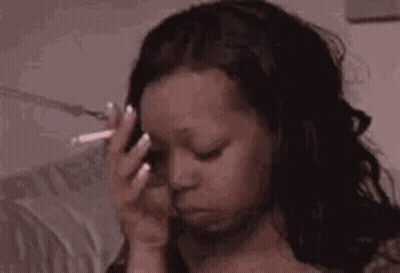 Woman Smoking Cigarette And Holding Forehead GIF