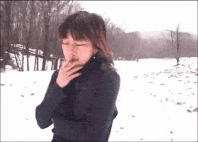 Woman Smoking Cigarette In Snow GIF