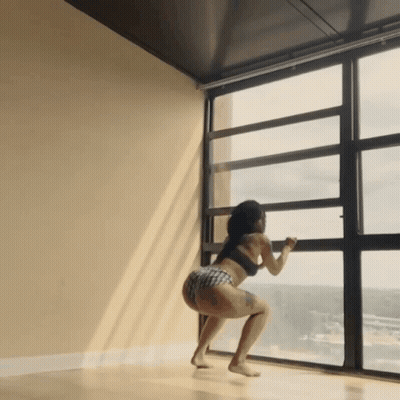 Woman Squatting By Large Window Looking Out GIF