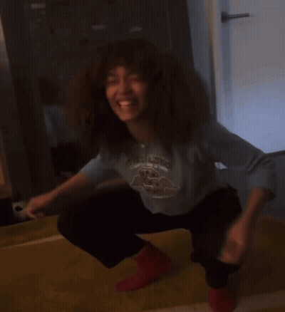 Woman Squatting In Blue Shirt With Bird And Red Socks GIF