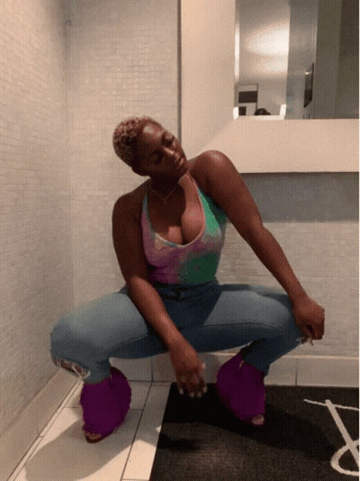 Woman Squatting in Front of Mirror in Purple Fuzzy Slippers