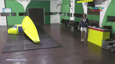 Woman Standing At Yellow Table #Pbbadultplane Task GIF